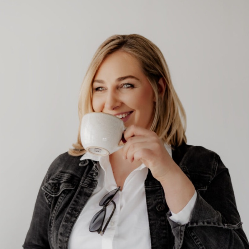 Sabine Schuster lacht herzlich mit Kaffeetasse — Einladung zum Erstgespräch